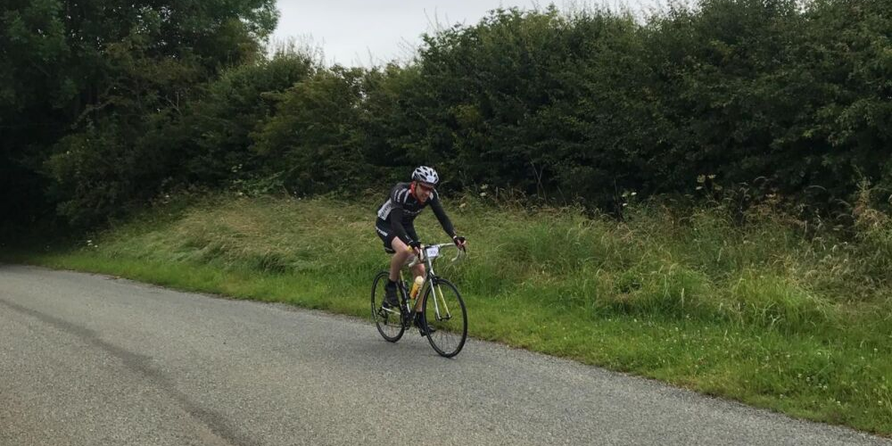 Rob on a bike cycling along a country road